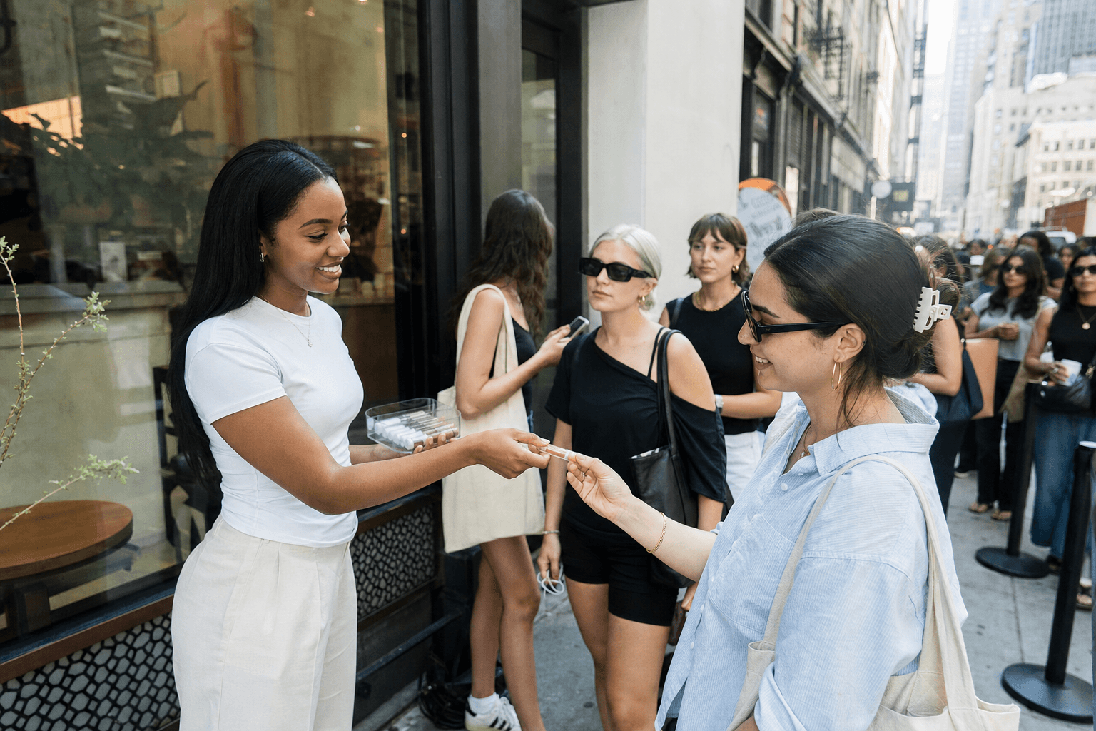 Brand ambassador handing product samples to customers waiting in line